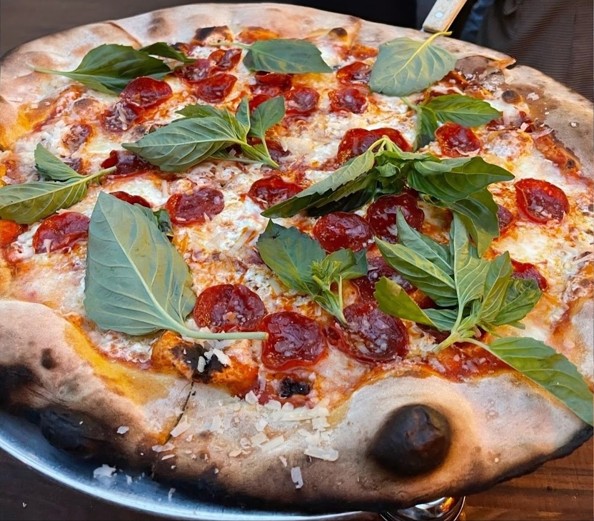 Two Neapolitan pizzas at Lucali in Carroll Gardens, Brooklyn: one cheese and basil, one with sliced cured ham.