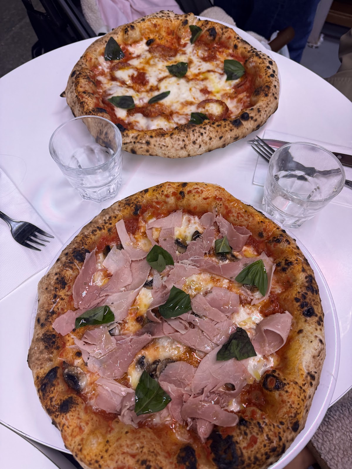 Neapolitan pizza with prosciutto and basil on a dining table at Dalmata in Les Halles, Paris.